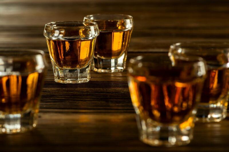 A wooden table with shots of whiskey or a cocktail called angry badger