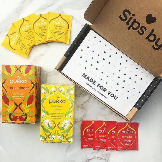 Various types of tea next to a sips by cardboard box