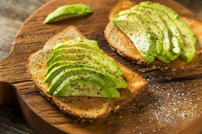 Two pieces of toast with sliced avocado, salt, and pepper