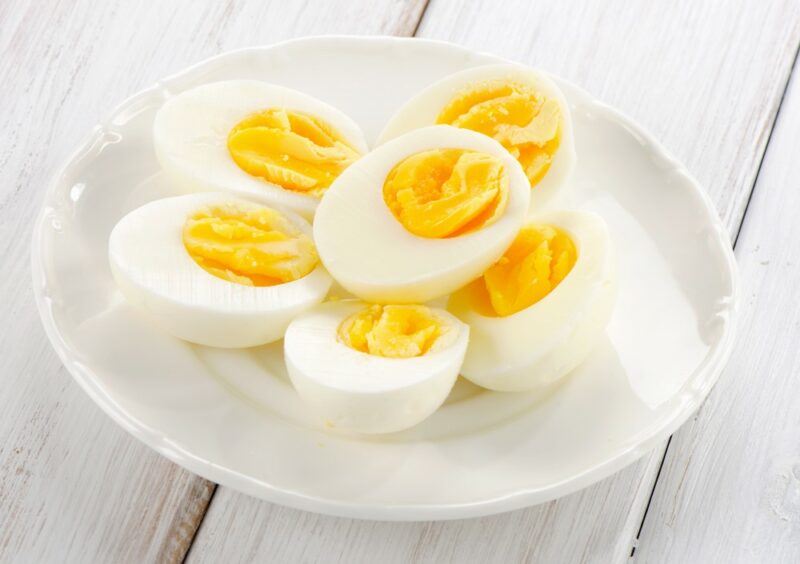 A white plate with hard boiled eggs that have been cut in half