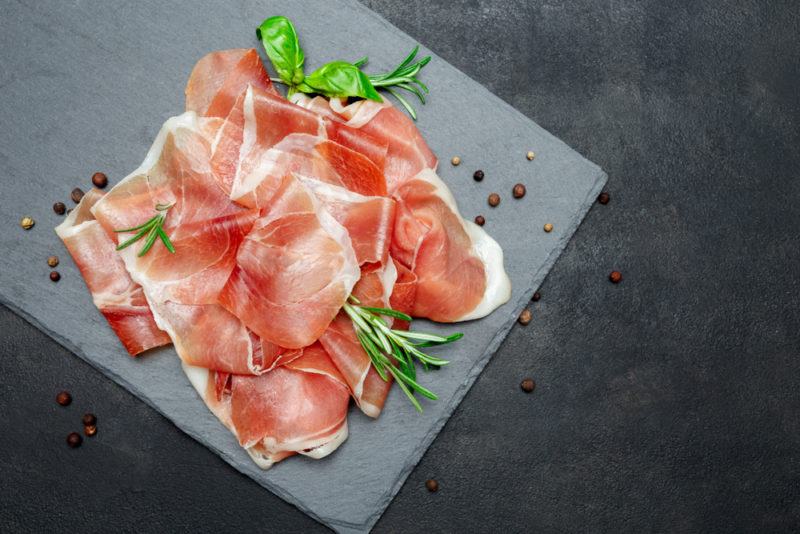 A gray slate with sliced prosciutto