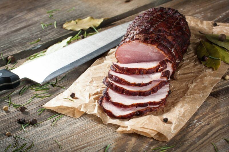 A large smoked ham that has been sliced into pieces