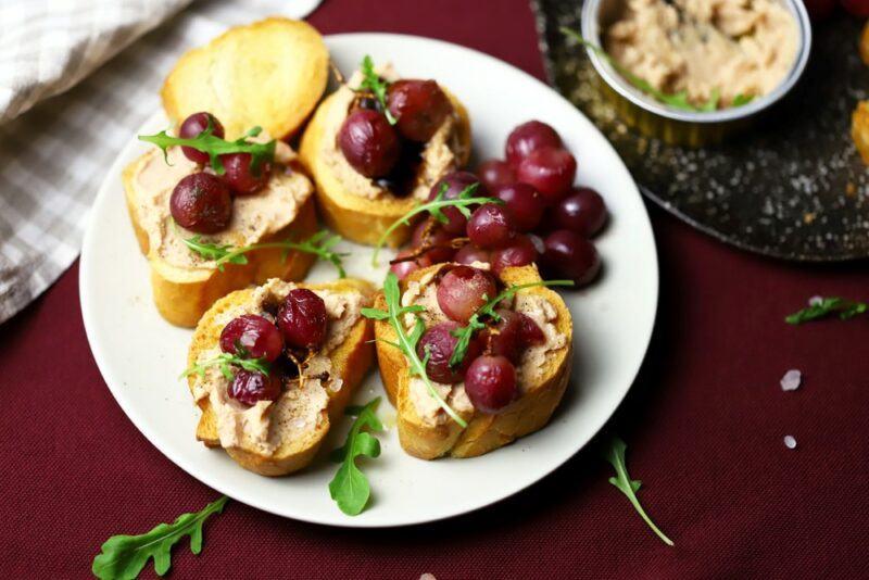 A white plate with slices of bread and grapes