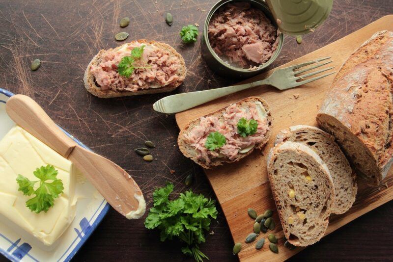 Slices of bread with fresh tuna next to some butter