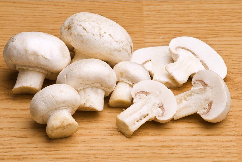 raw white mushrooms whole and sliced