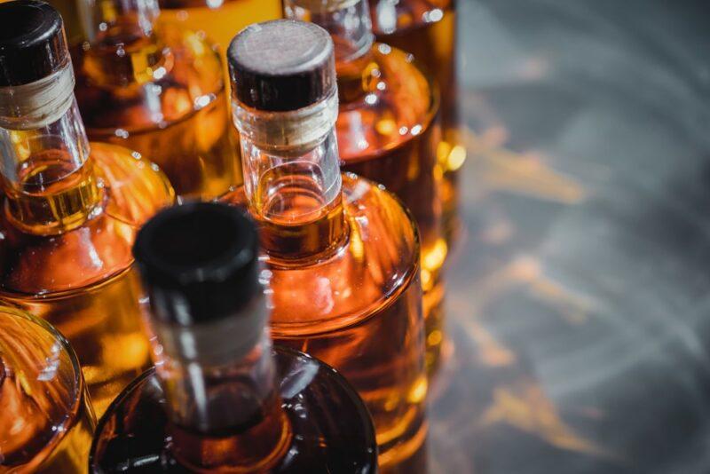 Various bottles of rum, with light passing through them and making patterns on the table