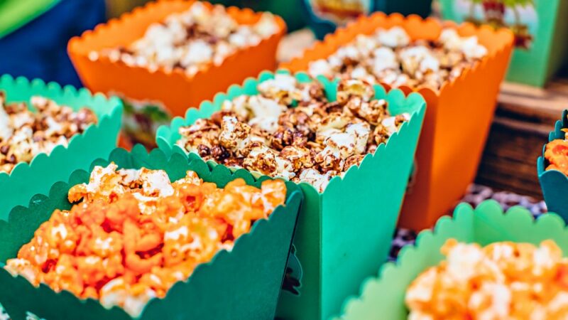 Orange and green containers filled with popcorn with seasoning