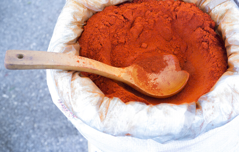 top view image of a sack full of smoked paprika with a big wooden ladle