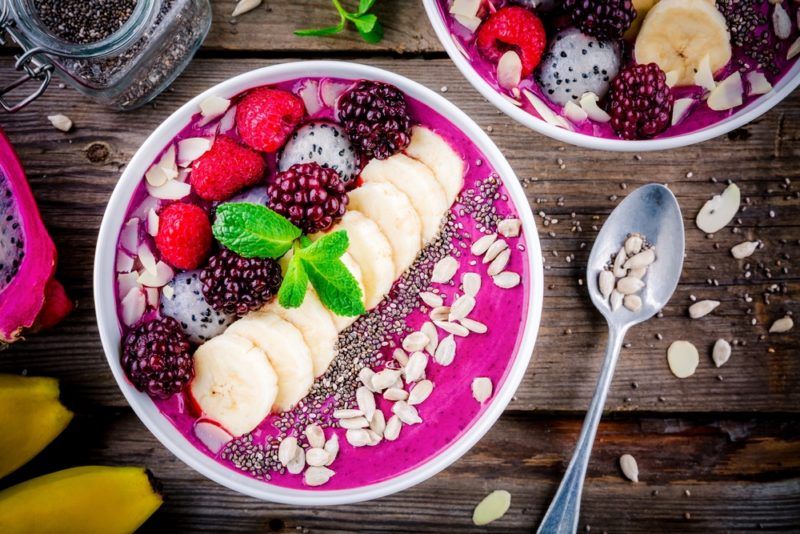 A white bowl with an acai smoothie and toppings