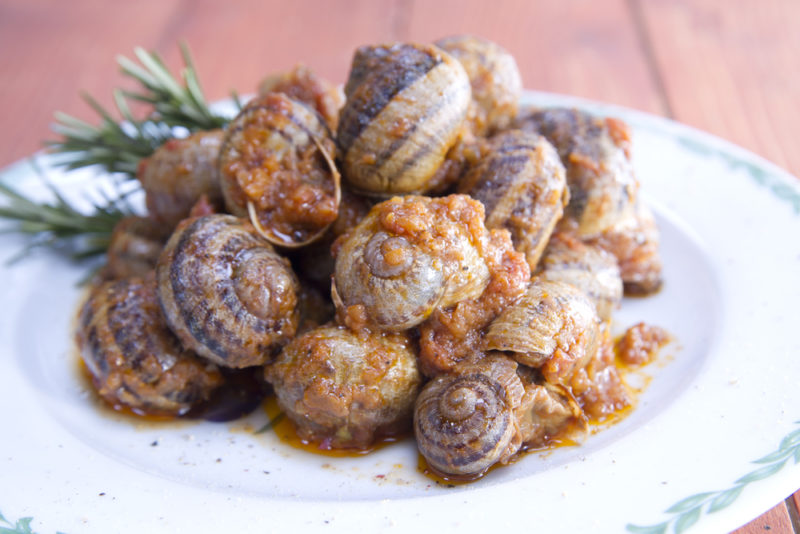 A dish of snails in limousine, where the peanuts are slightly visible