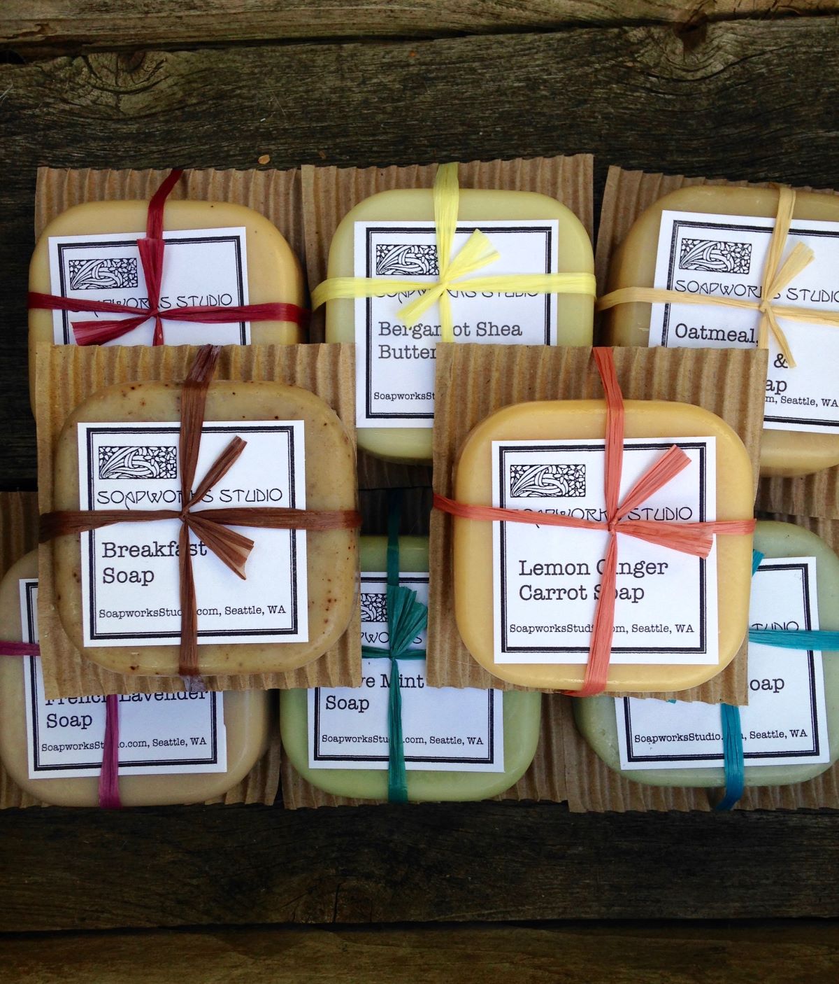 8 different bars of soap tied on cardboard, with raffia ribbon.  The soap are all different colors and fragrances like breakfast soap, and lemon ginger.