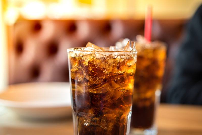 Two glasses of soda on a restaurant table, one out of focus