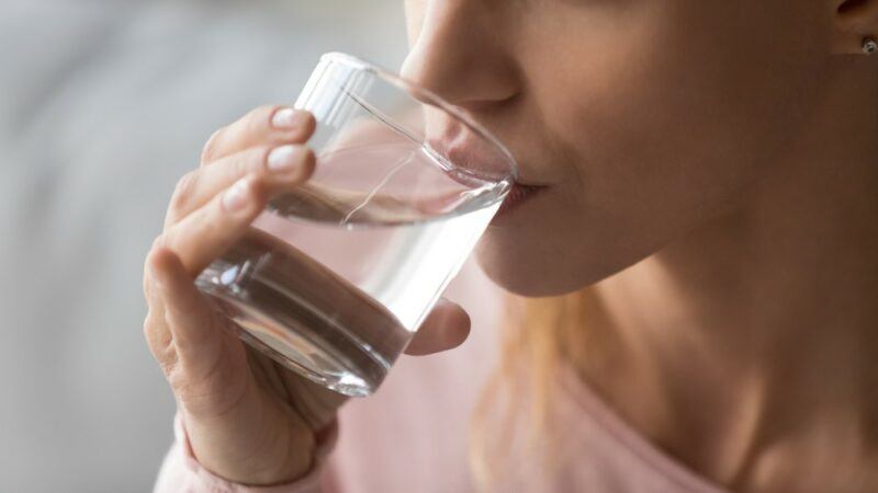 Someone drinking a glass of filtered water