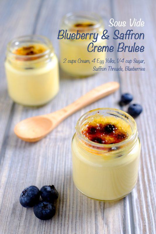 Three pots containing blueberry and saffron crème brûlée, next to a wooden spoon and some blueberries.