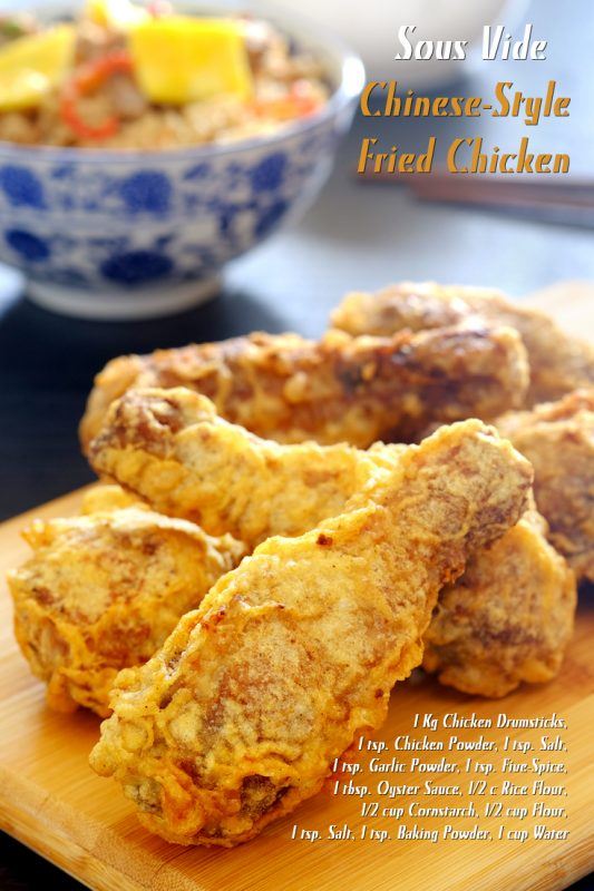 A wooden board with sous vide Chinese style fried chicken and a bowl of food in the background