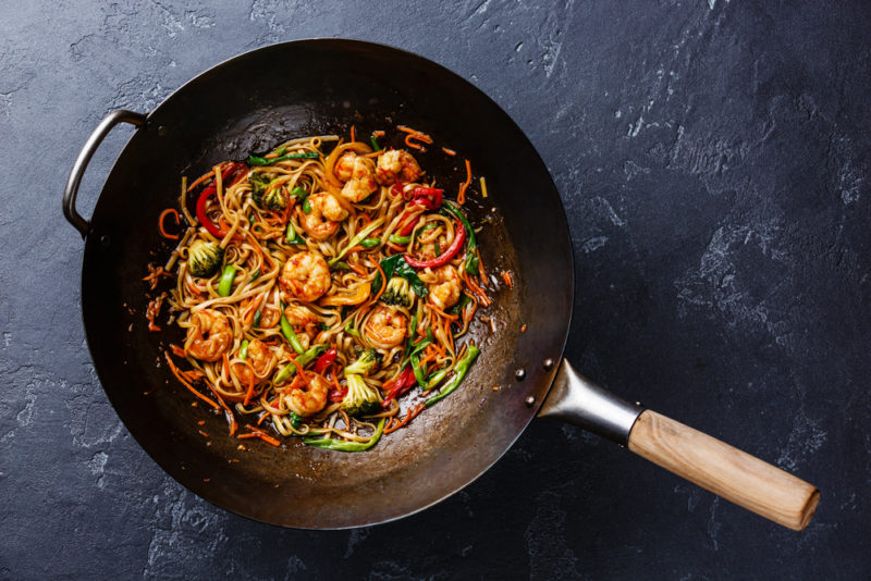 A frying pan of a spicy Asian meal on a table