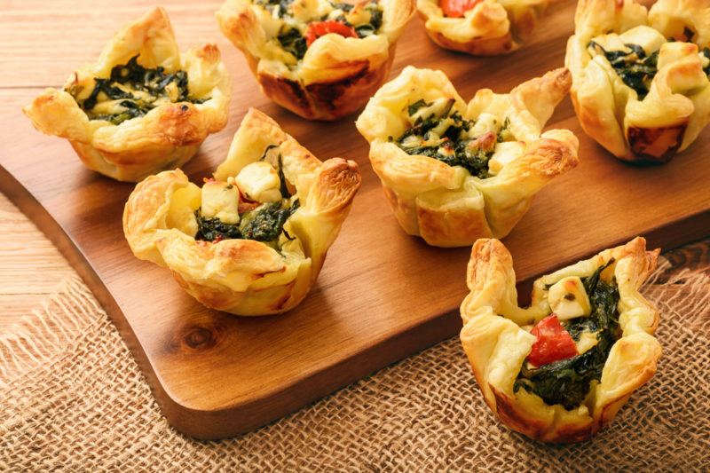 A collection of filo pastry apptetizers containin spinach