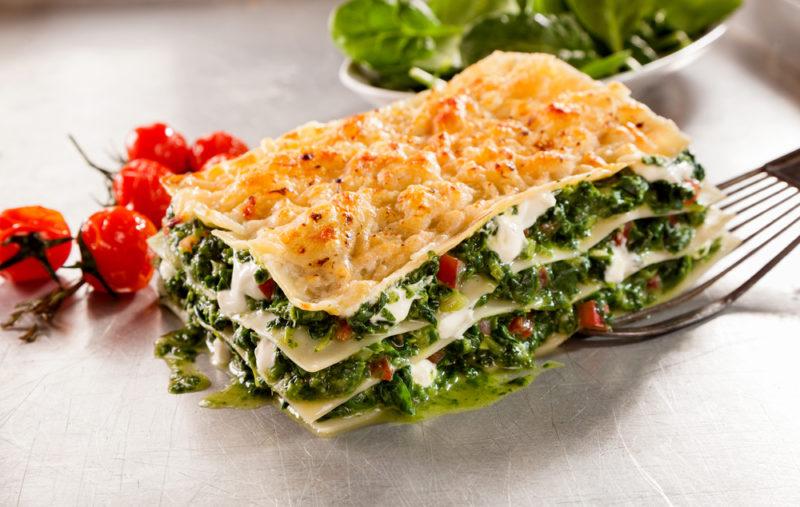 Lasagna that uses spinach and no meat on a white plate