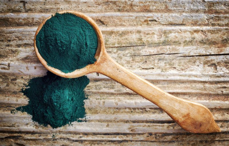 A spoon of spirulina on a table