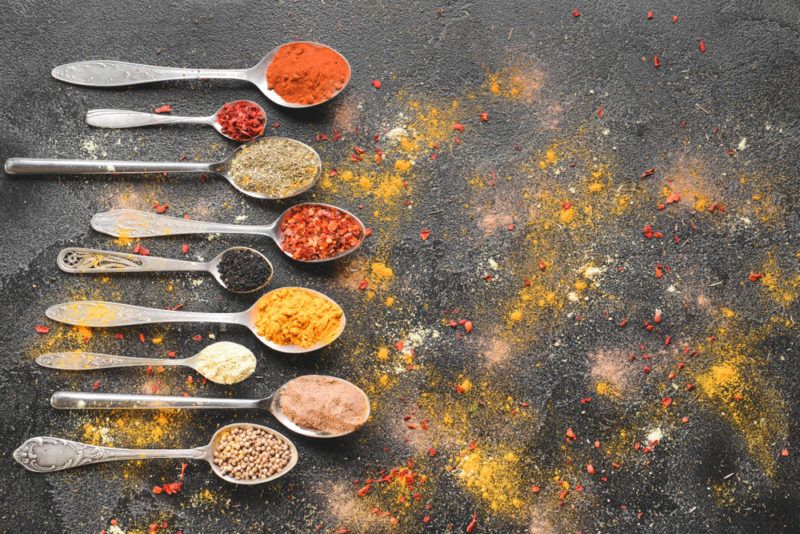 Spoons with spices on a black background