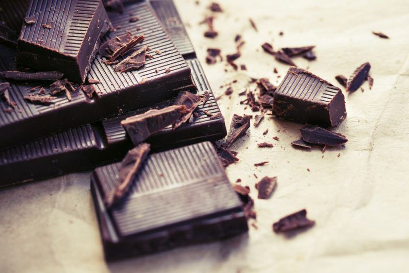 Squares of dark chocolate and some chocolate shavings on a table