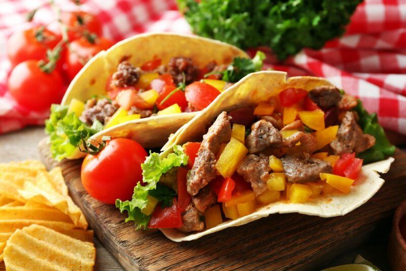 Two steak tacos with bell peppers and tomatoes