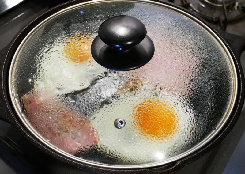 Basting eggs in a frypan