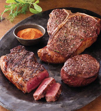 A set of 3 steaks on a black plate