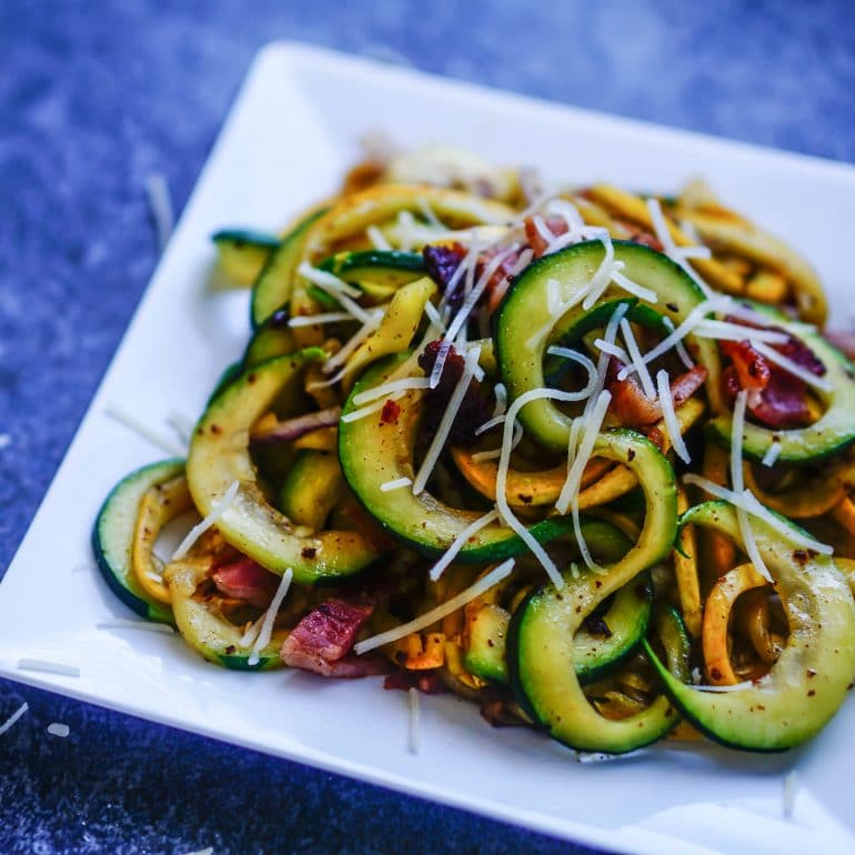 A square white plate with zoodles