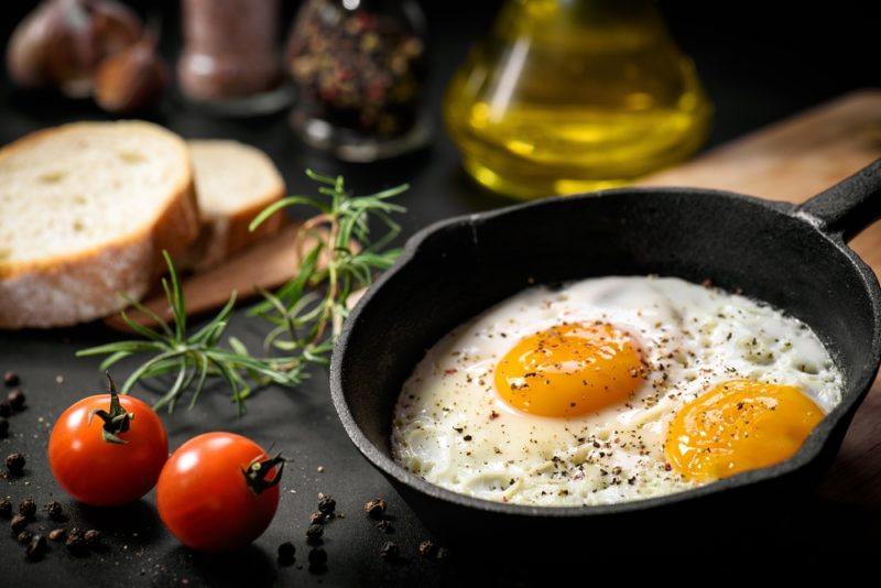 Sunny side up fried eggs in a small cast iron pan