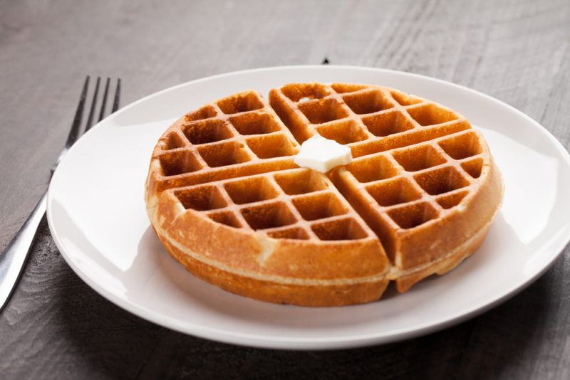 A white plate with a large sweet milk waffle