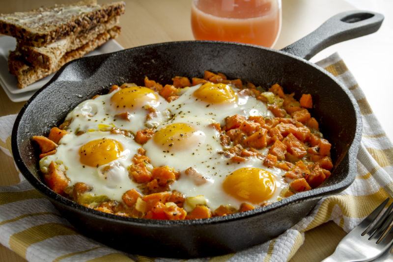 A cast iron pan with baked beans and eggs