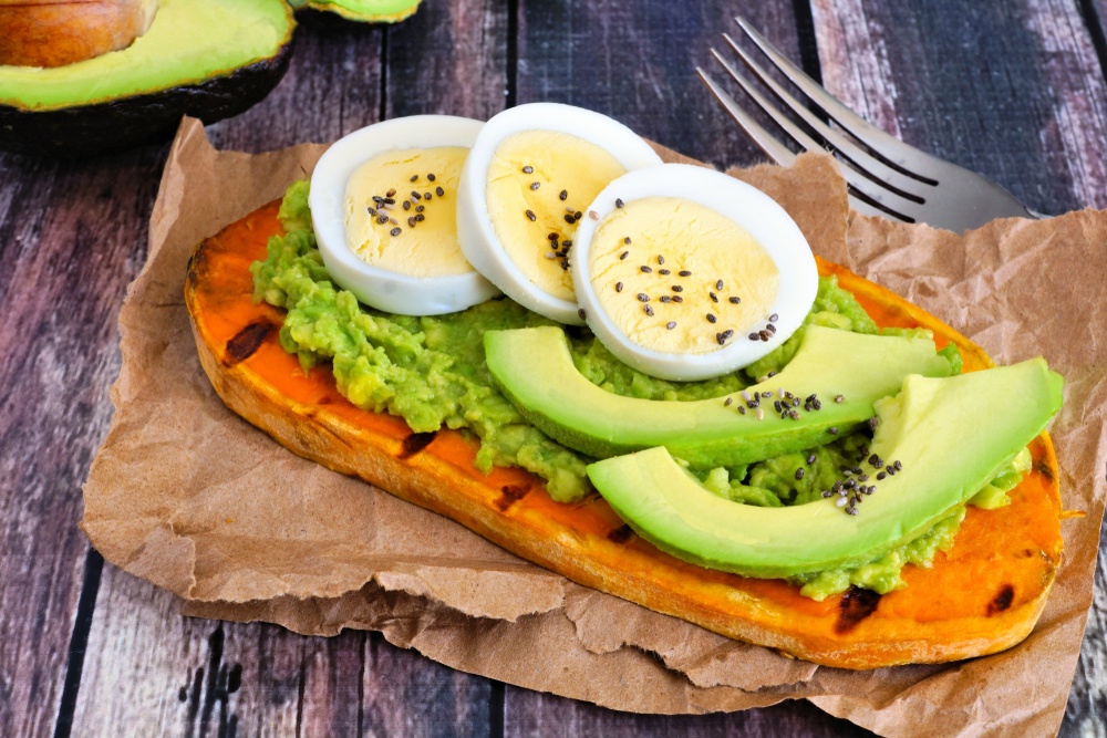 A slice of roasted sweet potato with avocado and eggs