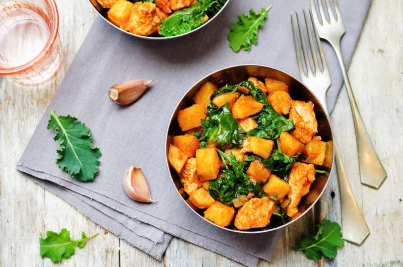 Two bowls containing cooked sweet potatoes and garnish