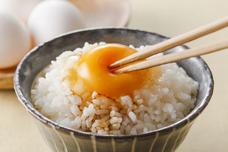 A bowl of rice with a raw egg