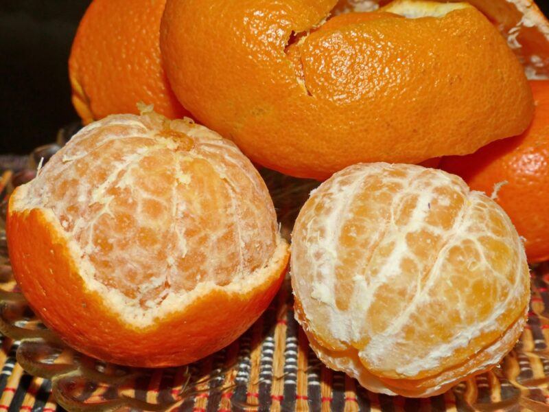 a closeup image of a couple of tangerines that are partially peeled