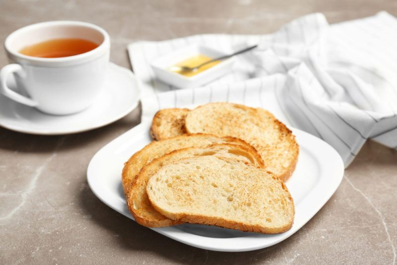 A plate of toast next to a mug of tea