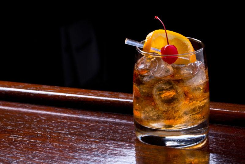 A Tequila Old Fashioned against a black background