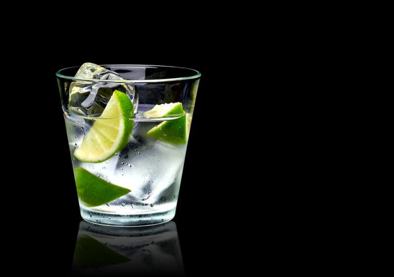 A tequila and tonic cocktail on a black background