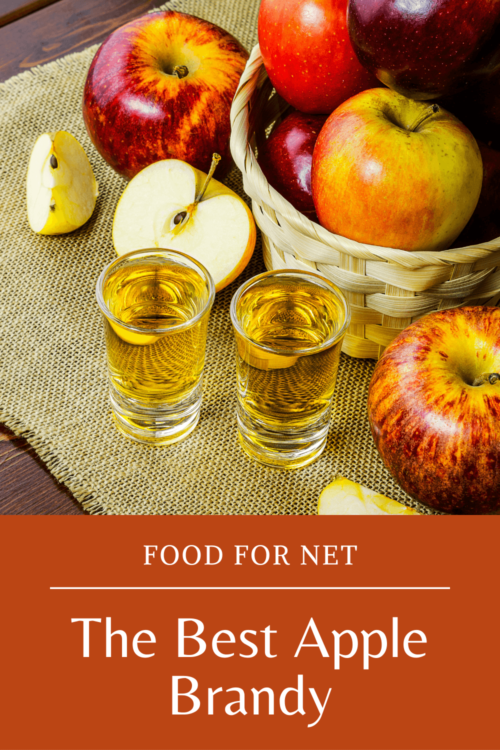 Best Apple Brandy. Two glasses of apple brandy next to a basket of apples and a few apples on a cloth