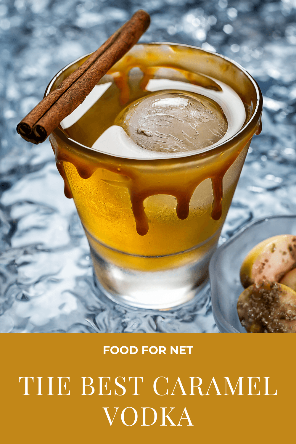 A glass of caramel vodka with a ball of ice, caramel and a cinnamon stick as a garnish