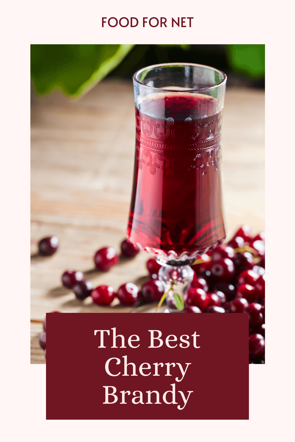 Best Cherry Brandy. A tall glass of cherry brandy with cherries around it on a wooden table, showing the idea of the best cherry brandy