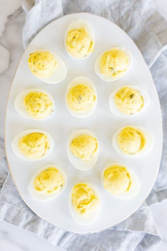 A large white oval dish with deviled eggs