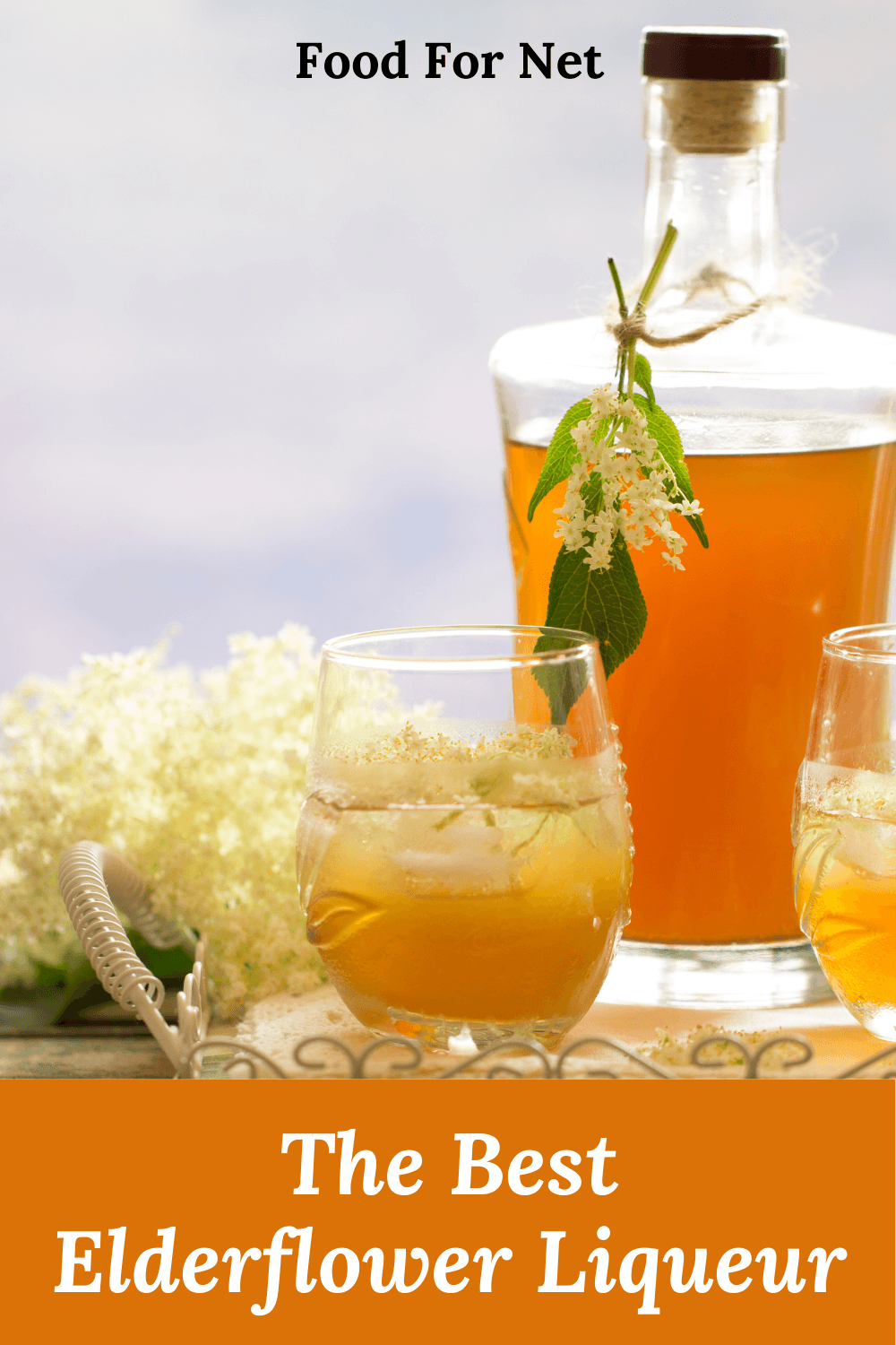 Two glasses and a bottle of elderflower liqueur on a table