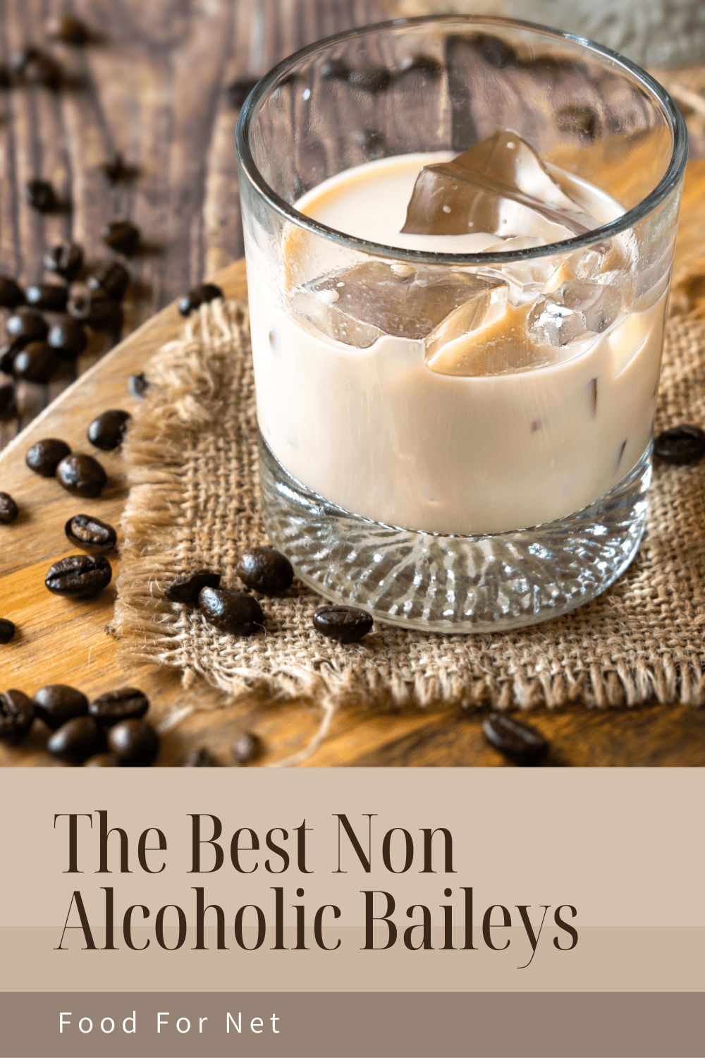 A glass of non alcoholic Baileys with ice, sitting on a cloth mat with coffee beans