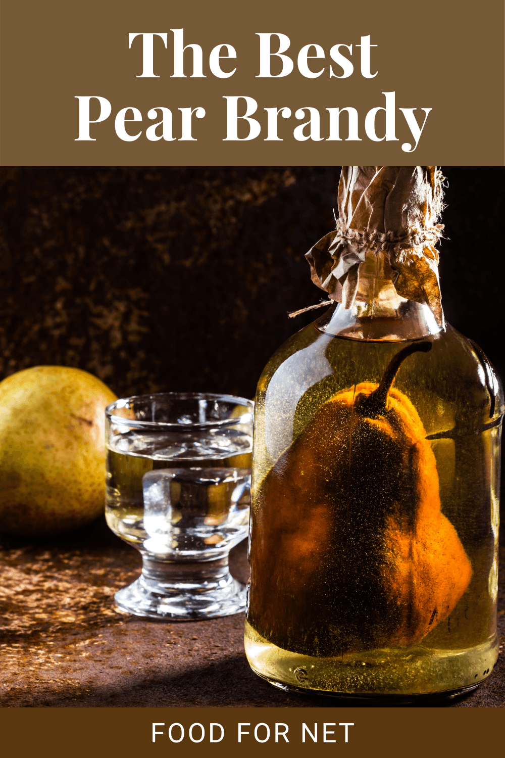 A bottle of pear brandy with the pear in it, next to a shot glass and a pear