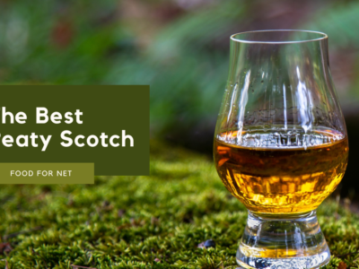 A glass of peaty Scotch on a mossy tree or mound, highlighting the idea of the best peaty Scotch