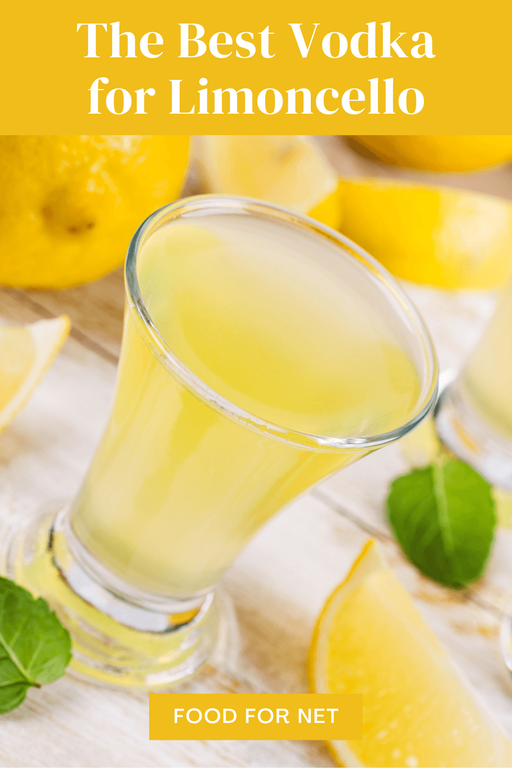 Glasses of homemade limoncello surrounded by lemon wedges, highlighting the idea of the best vodka for limoncello