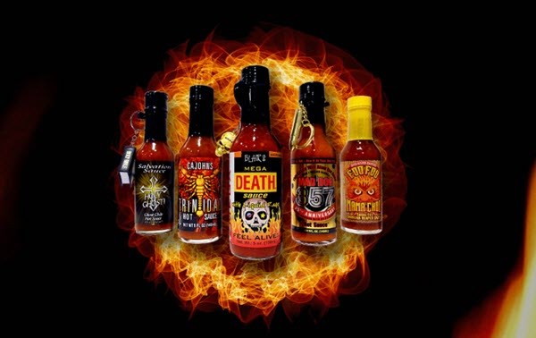 Five bottles of hot sauce against a fiery background