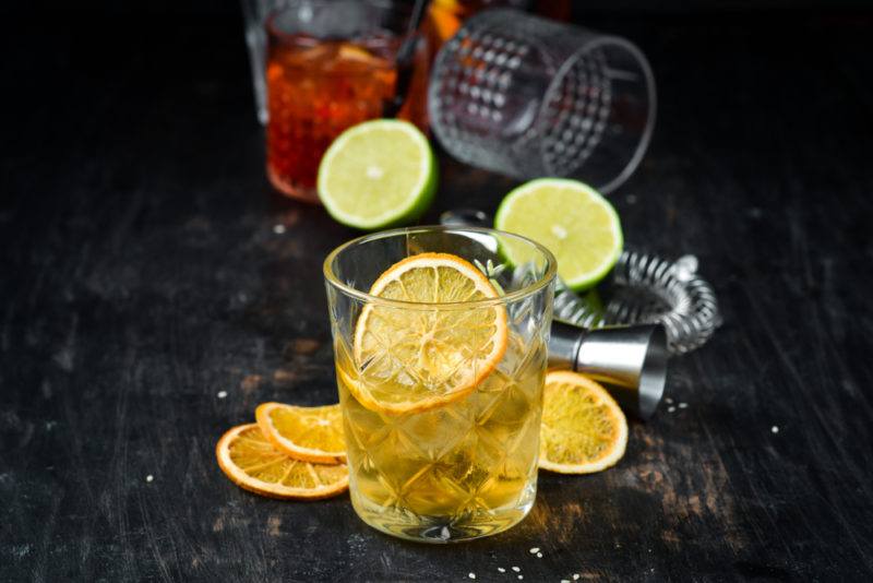 A Godfather cocktail on a table with mixing tools and ingredients